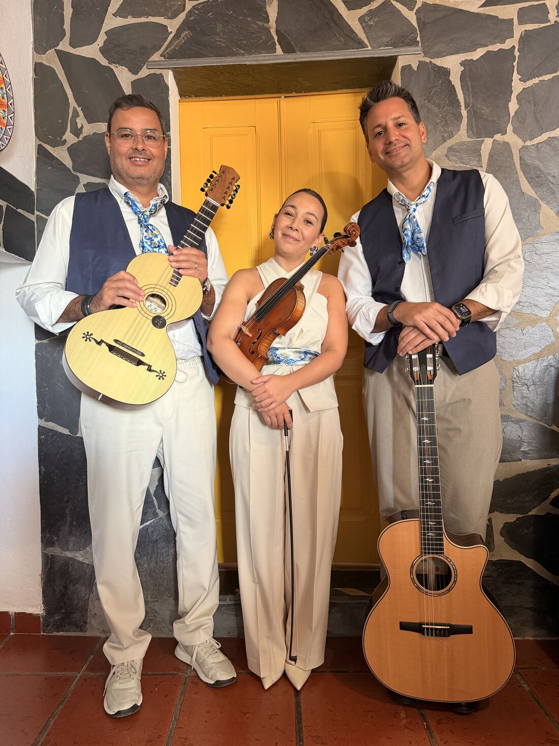 O trio de pé em frente a uma porta amarela