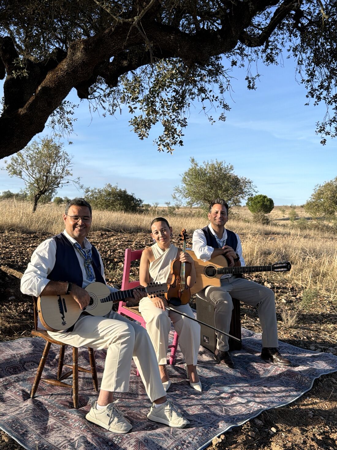 O trio sentado sobre um tapete à sombra